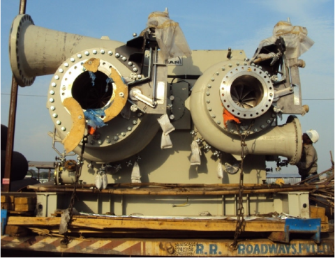 Eine große industrielle Ventilbaugruppe mit mehreren Rohren und Komponenten, die auf einer hölzernen Plattform auf einem Schiff befestigt sind.